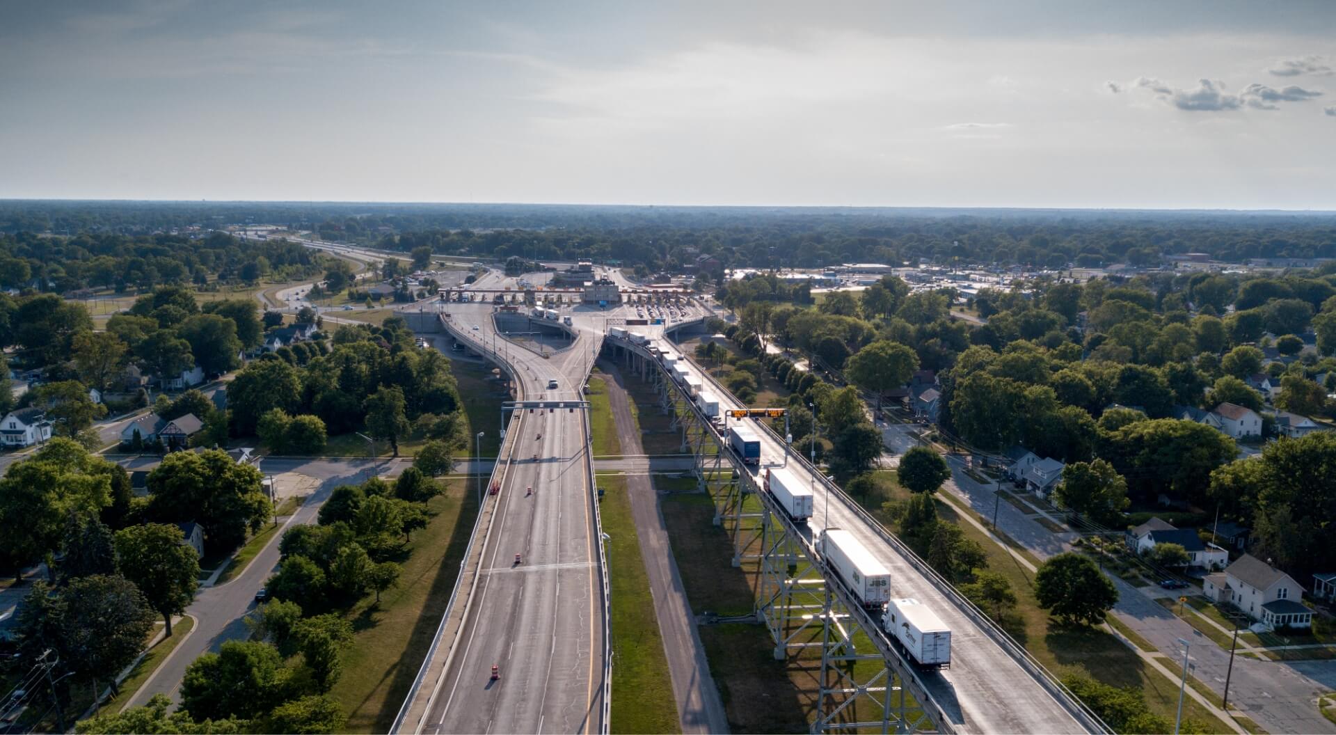 aerial view of roadways and vehicles converging into a border crossing